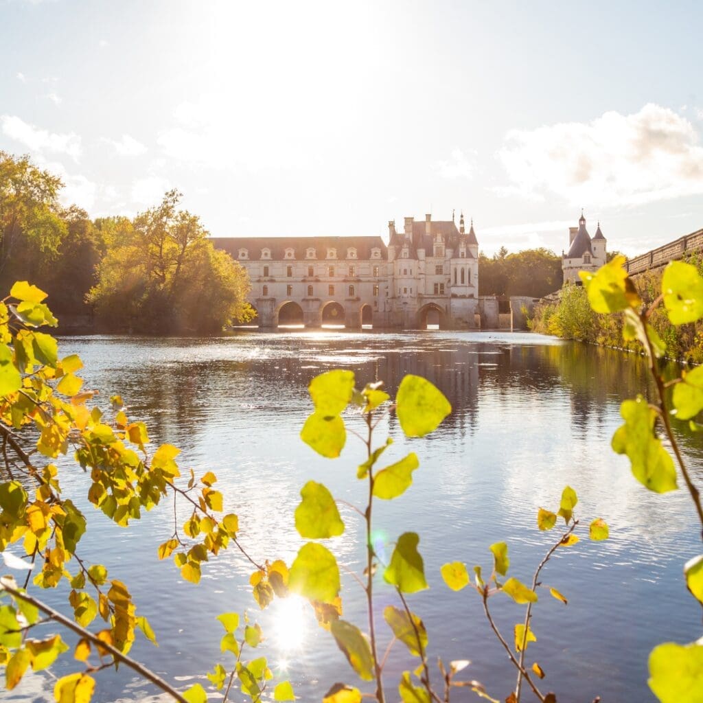 Chateau de Chenonceau reflected in the Cher River at golden hour in the Loire Valley, France
