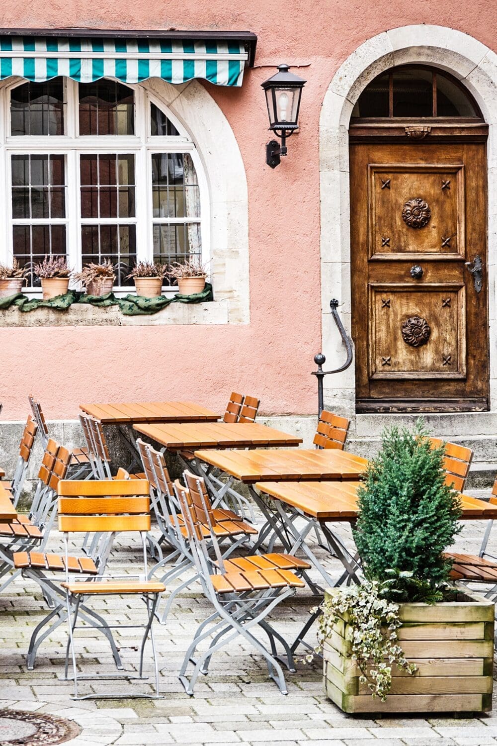 Charming Paris cafe with pink facade and outdoor seating, neighborhood bistro France small group travel