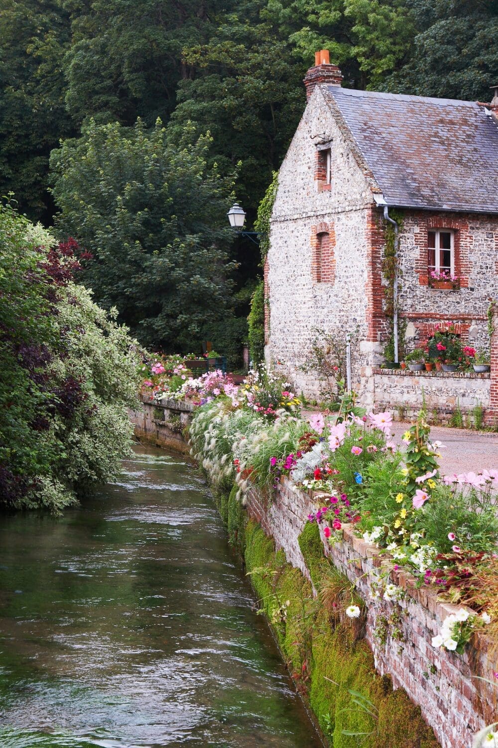 Stone cottage with flower lined river at Veules-les-Roses Normandy secret French village